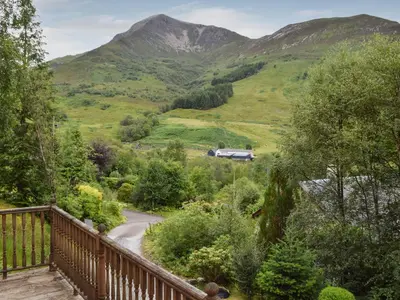 a balcony with a view of a valley with mountains at Tamarchan Lodge in Ballachulish