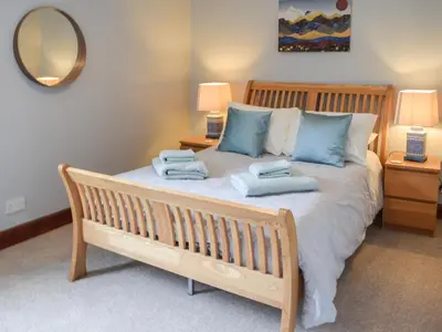 a bedroom with a bed with two towels on it at Tamarchan Lodge in Ballachulish