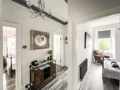 a living room with white walls and a mirror at Osborne Place in Rothesay