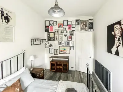 a bedroom with a bed and a wall of pictures at Osborne Place in Rothesay