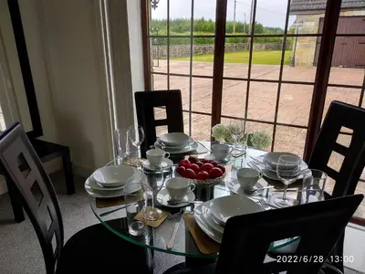a table with plates and bowls of fruit on it at Cottage with Panoramic Views in Kirk of Shotts