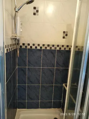 a shower with a black and white tile at Cottage with Panoramic Views in Kirk of Shotts