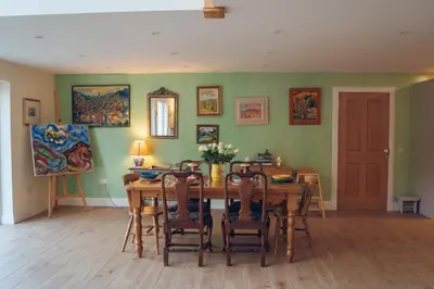 a dining room with a wooden table and chairs at Claggan Farmhouse, Loch Tay in Aberfeldy