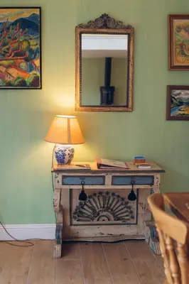 a lamp on a table in a room with a mirror at Claggan Farmhouse, Loch Tay in Aberfeldy