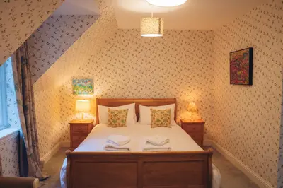 a bedroom with a bed with two night stands at Claggan Farmhouse, Loch Tay in Aberfeldy