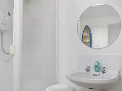 a white bathroom with a sink and a mirror at Bay View in Brodick