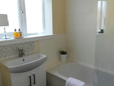 a bathroom with a sink and a bath tub at Larkfield in Lamlash