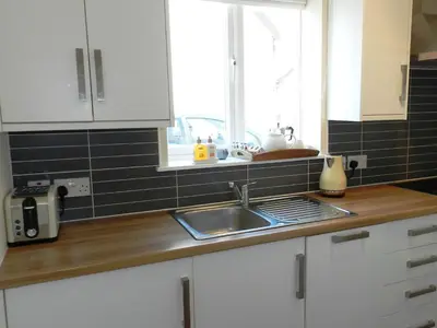 a kitchen counter with a sink and a window at Larkfield in Lamlash