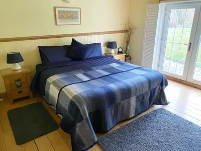 a bedroom with a bed with a blue comforter at Glenfruin Lodge in Helensburgh