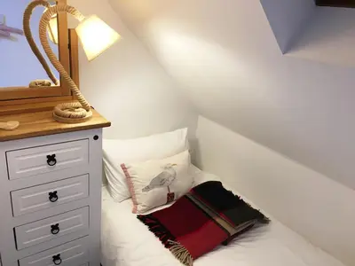 a bedroom with a bed and a dresser with a mirror at The Apostles in Catacol