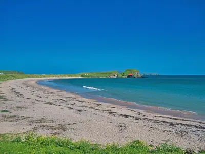 a beach with the ocean in the background at Port Righ Cottage in Carradale