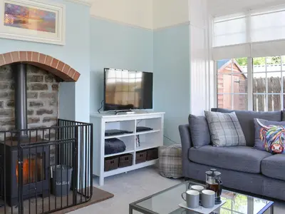 a living room with a couch and a tv at 1 Hamilton Terrace in Lamlash