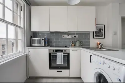 a white kitchen with a stove and a dishwasher at Edinburgh Castle Apartment G1 in Edinburgh