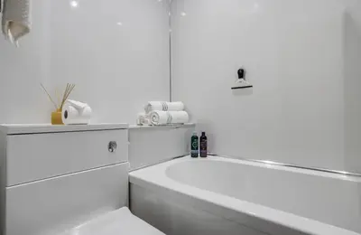 a white bathroom with a tub and a toilet at Edinburgh Castle Apartment G1 in Edinburgh