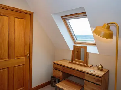 a attic room with a desk and a window at Kringlands in Stranraer