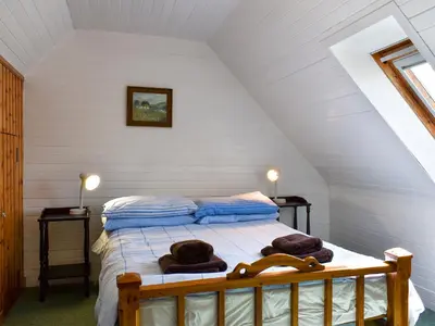 a bedroom with a bed with towels on it at Burnside Cottage in Sliddery