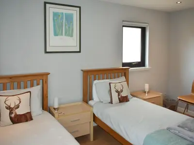 a bedroom with two beds and a window at Rivendell in Lamlash