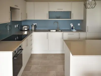 a kitchen with white cabinets and a sink at Rivendell in Lamlash