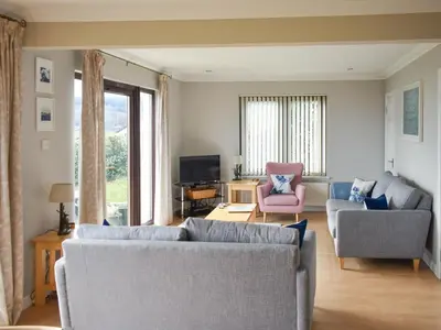 a living room with two couches and a tv at Rivendell in Lamlash