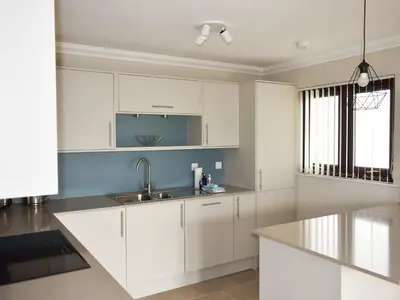 a kitchen with white cabinets and a sink at Rivendell in Lamlash