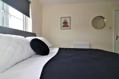 a bedroom with a bed with a black and white pillow at Signature - Harris House in Glasgow