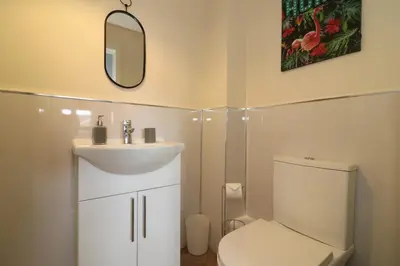 a bathroom with a toilet and a sink and a mirror at Signature - Harris House in Glasgow