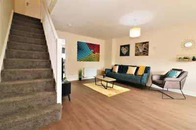 a living room with a staircase and a couch at Signature - Harris House in Glasgow