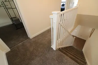 a hallway with a white staircase with carpet at Signature - Harris House in Glasgow