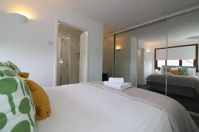 a bedroom with a large white bed and a mirror at Signature - Barons Court in Paisley