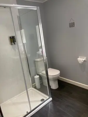 a bathroom with a toilet and a glass shower at Edgemont Annexe Oban in Oban