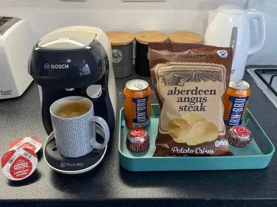 a tray with a cup of coffee and a bag of american anzacrax at Edgemont Annexe Oban in Oban