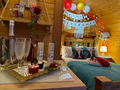 a room with a table with wine glasses and balloons at FINN VILLAGE - Loch Lomond Sunset Glamping Pod - Private Ofuro HOT TUB in Drymen