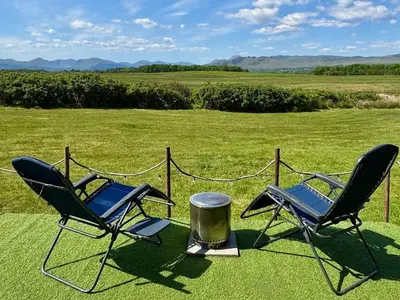two chairs sitting on top of a field at FINN VILLAGE - Loch Lomond Sunset Glamping Pod - Private Ofuro HOT TUB in Drymen