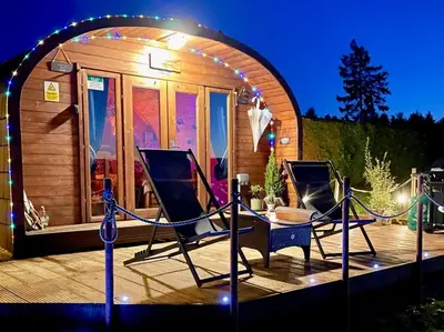 two chairs on a deck in front of a tiny house at FINN VILLAGE - Loch Lomond Sunset Glamping Pod - Private Ofuro HOT TUB in Drymen
