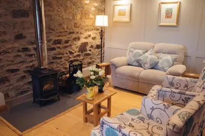 a living room with a couch and a wood stove at Shepherds Forge, Loch Tay in Aberfeldy