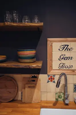 a kitchen with a sink and a shelf with dishes at Shepherds Forge, Loch Tay in Aberfeldy