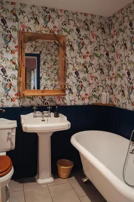 a bathroom with a tub and a sink and a mirror at Shepherds Forge, Loch Tay in Aberfeldy