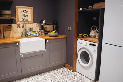 a kitchen with a sink and a washing machine at Shepherds Forge, Loch Tay in Aberfeldy