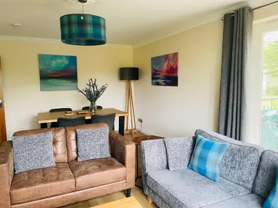 a living room with a couch and a chair at Turnberry Apartment - Ailsa Gem in Turnberry