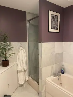 a bathroom with a shower and a tub and a sink at Turnberry Apartment - Ailsa Gem in Turnberry