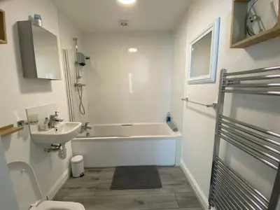a bathroom with a tub and a sink and a toilet at Beautiful Riverside Holiday Home in Callander