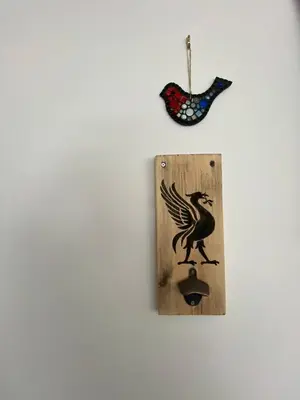 a wall with a bird sign and a clock at Beautiful Riverside Holiday Home in Callander