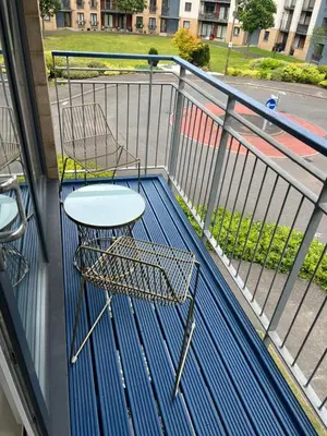a balcony with a table and chairs on a balcony at Strada Apartment in Edinburgh
