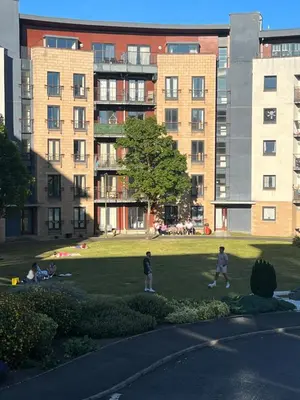 a group of people walking in a park with buildings at Strada Apartment in Edinburgh