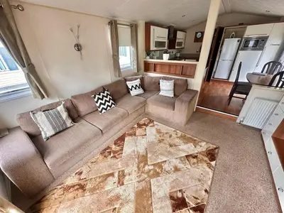 a living room with a couch and a kitchen at 2-Bedroom Caravan Located in Uddingston, Glasgow at Maryville Caravan Site in Uddingston