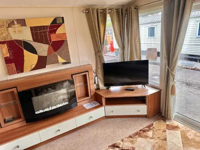 a living room with a flat screen tv and a entertainment center at 2-Bedroom Caravan Located in Uddingston, Glasgow at Maryville Caravan Site in Uddingston