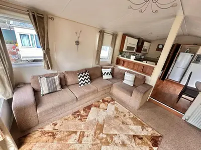 a living room with a couch and a kitchen at 2-Bedroom Caravan Located in Uddingston, Glasgow at Maryville Caravan Site in Uddingston