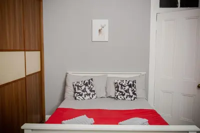 a small bedroom with a bed with a red blanket at Bonhill Getaway in Dumbarton