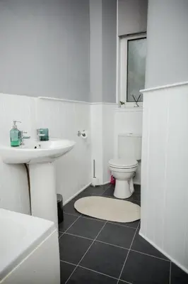 a white bathroom with a sink and a toilet at Bonhill Getaway in Dumbarton
