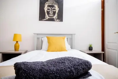 a bedroom with a large white bed with a yellow pillow at Rigside House in Douglas